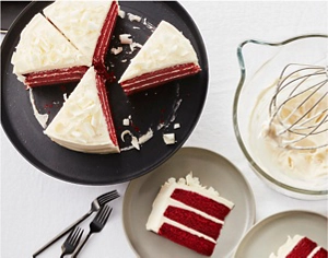 A sliced red velvet cake on a black serving tray