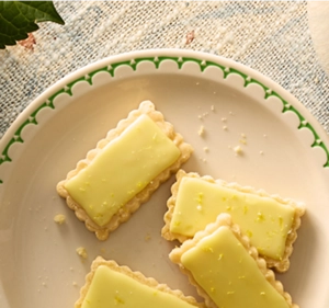 Four shortbread cookies glazed in a pale yellow yuzu glaze.