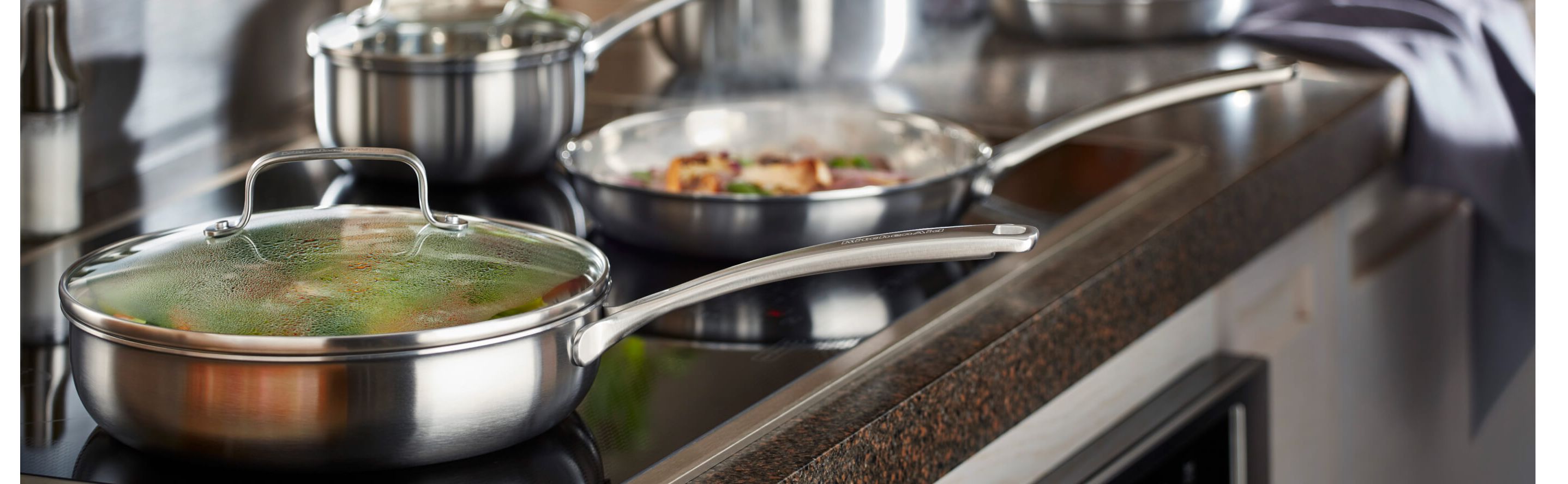 A stainless steel skillet on a KitchenAid brand induction cooktop