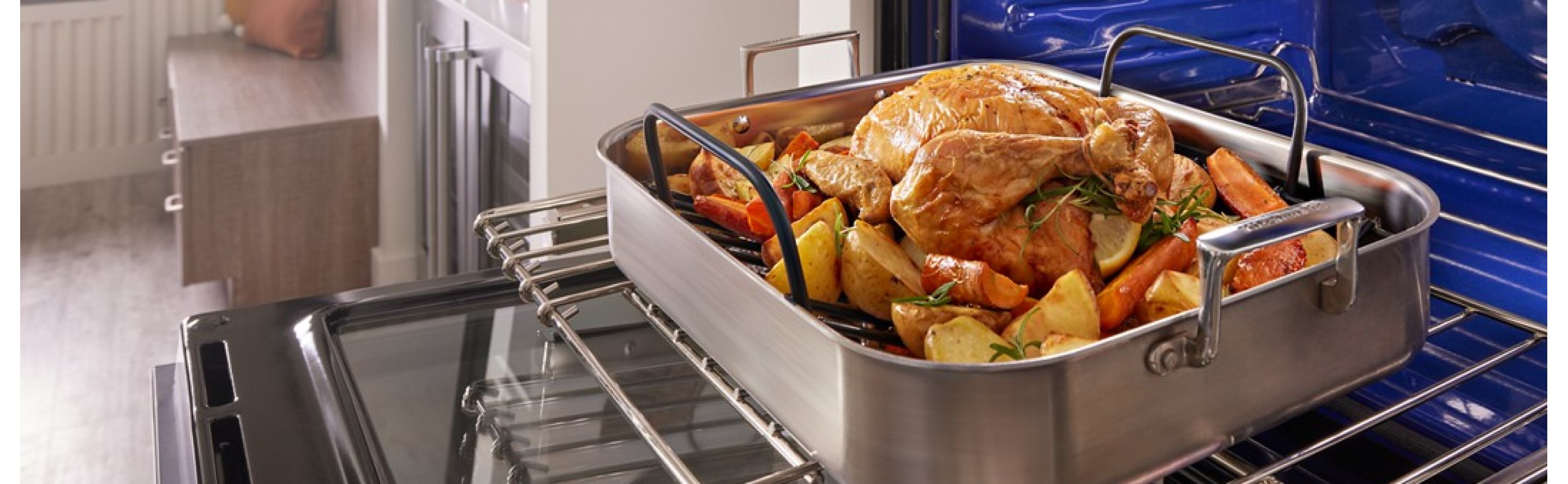A turkey and vegetables in an air fry basket in a KitchenAid® wall oven