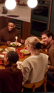 People sitting at a table with food and drinks.