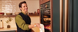 Chef Antoni Porowski removing a pan from a KitchenAid® wall oven