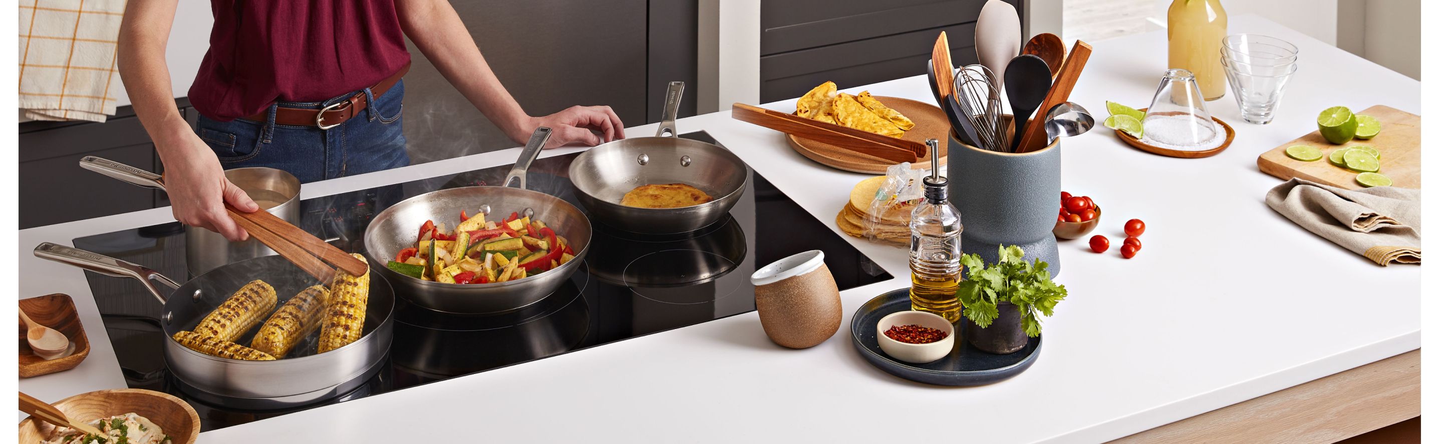 Multiple dishes cooking on a KitchenAid induction cooktop