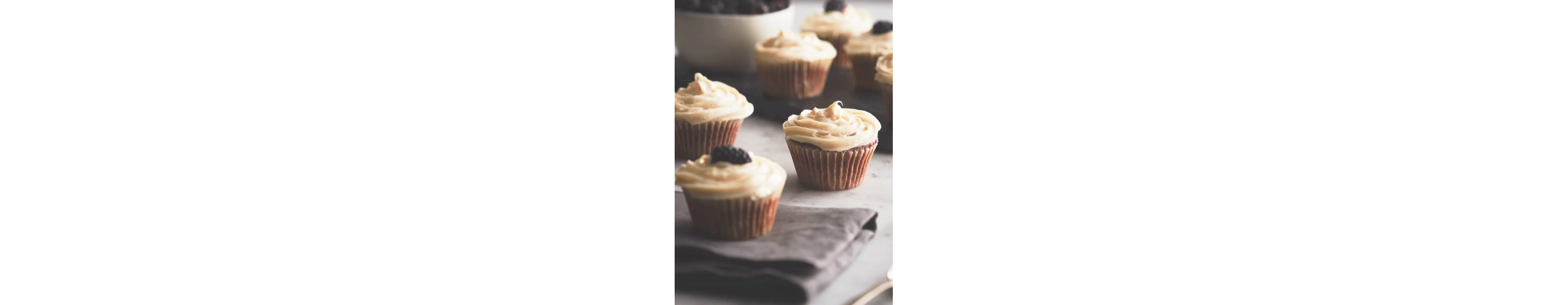 Close-up of cupcakes with white frosting on a countertop