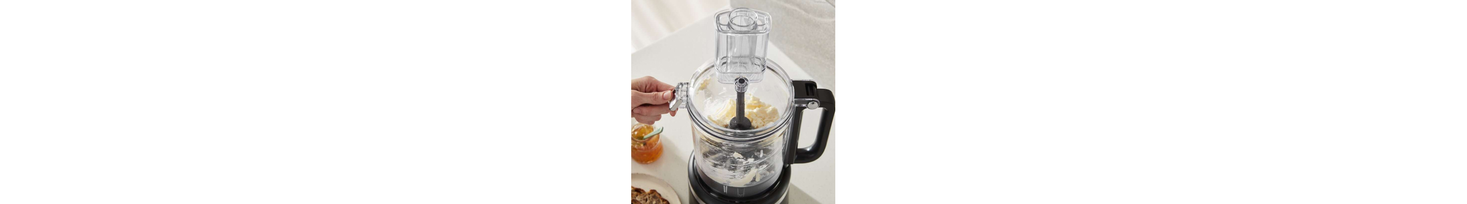 Person processing ingredients in a black KitchenAid® food processor