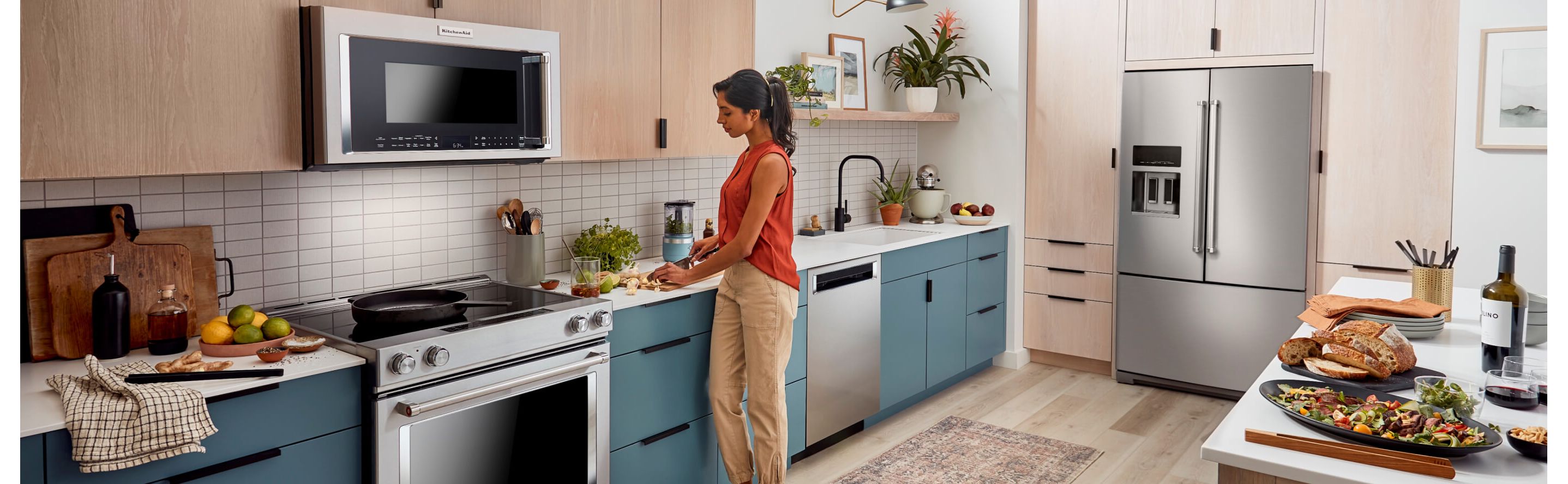 A kitchen with wood cabinets and a french door stainless steel refrigerator