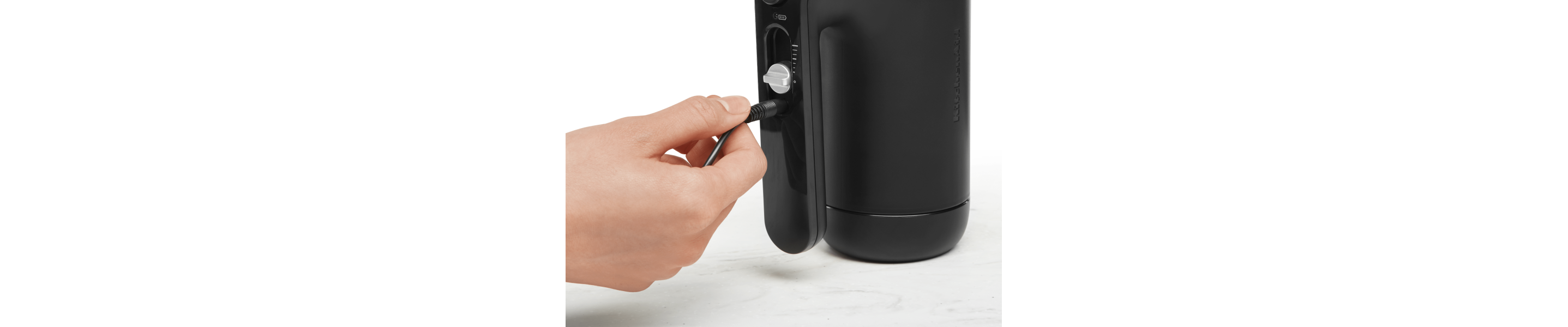 Maker plugging cord into black KitchenAid® hand mixer