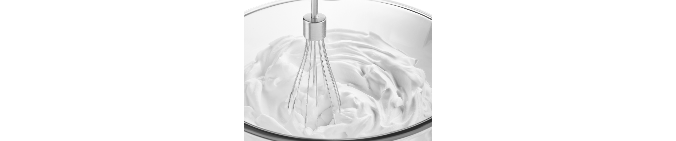 Close up of wire whisk beating white cream in glass bowl