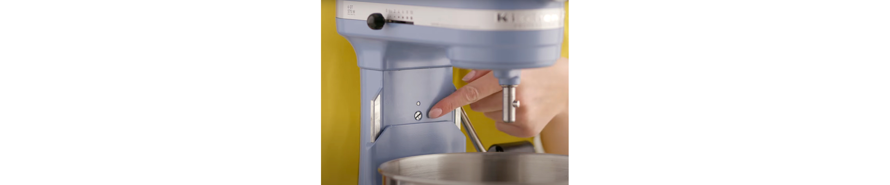 A person pointing to the screw on a blue bowl-lift stand mixer