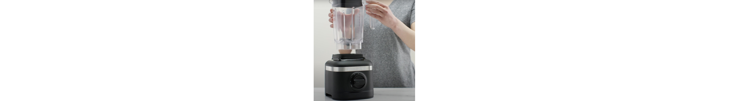 Person removing blender jar from black base of KitchenAid® blender