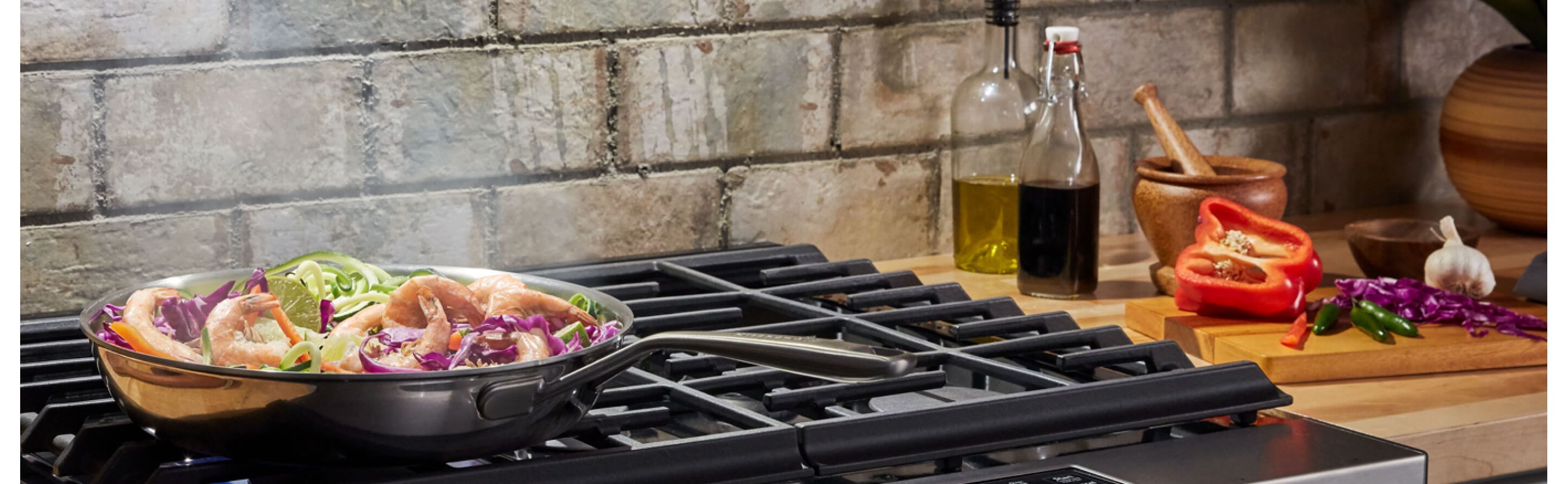 Shrimp stir fry sizzling over a gas range.