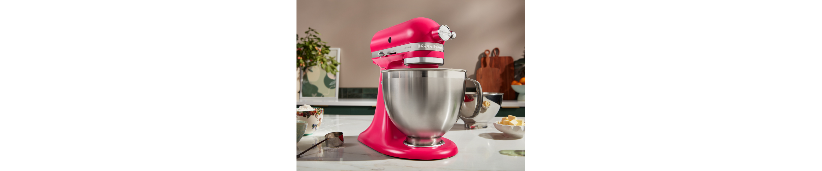 Hot pink KitchenAid® stand mixer on counter next to ingredients