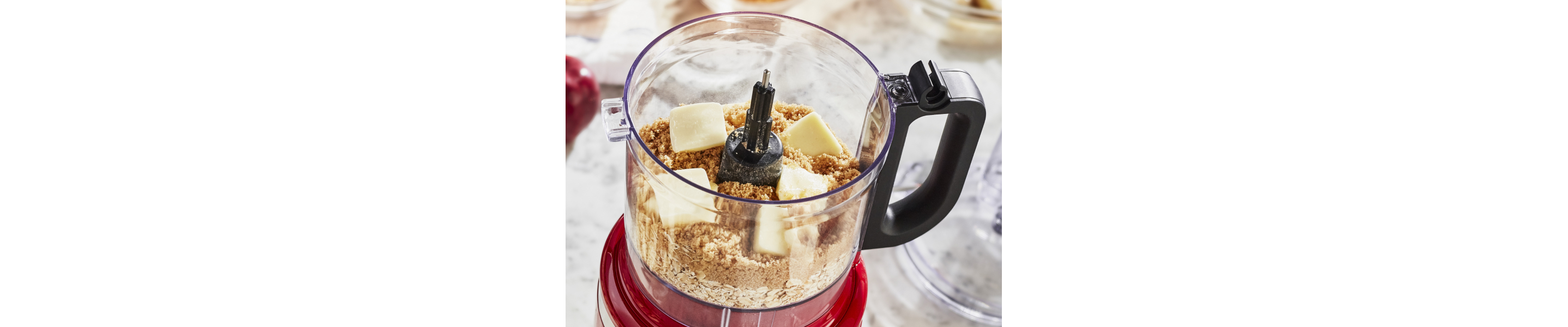 Crushed graham crackers and cubes of butter in a KitchenAid® food processor