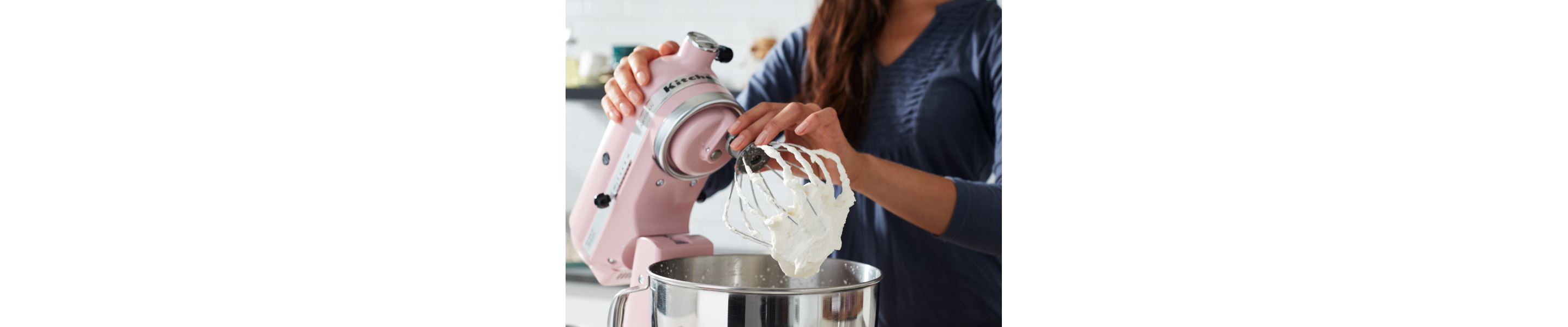 Person making whipped cream in a pink KitchenAid® stand mixer
