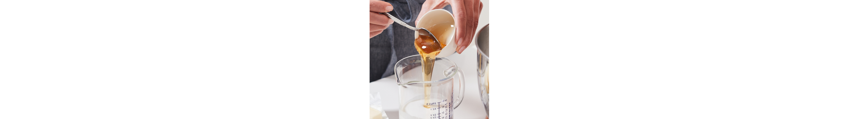 Person adding a liquid into a measuring cup