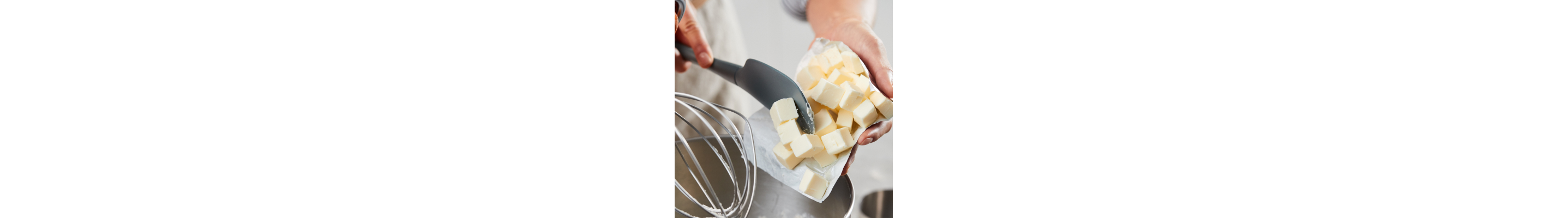 Person adding cubed butter into a KitchenAid® stand mixer bowl
