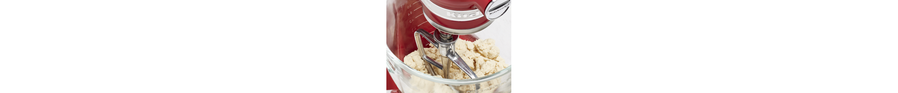 Dough inside the mixing bowl of a red KitchenAid® stand mixer