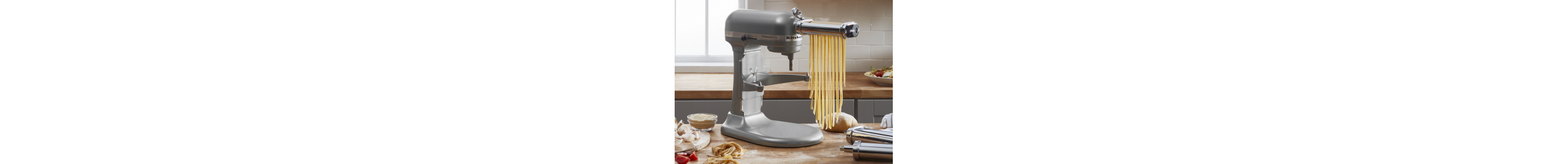 Long noodles being cut by a KitchenAid® stand mixer with the Pasta Roller Attachment