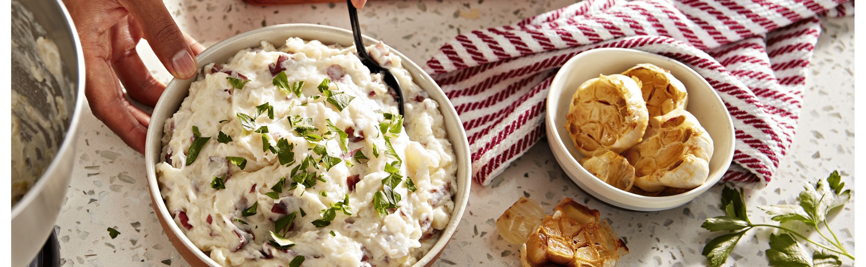 Bowls of red-skinned mashed potatoes and roasted garlic