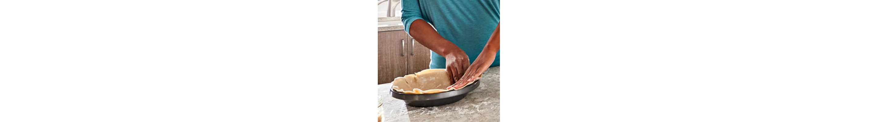 Maker shaping pastry dough into baking dish