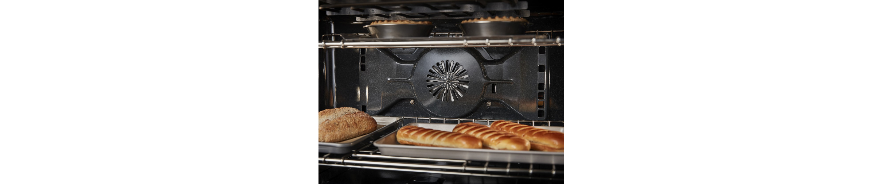 Close-up of bread and pies baking inside of an oven cavity