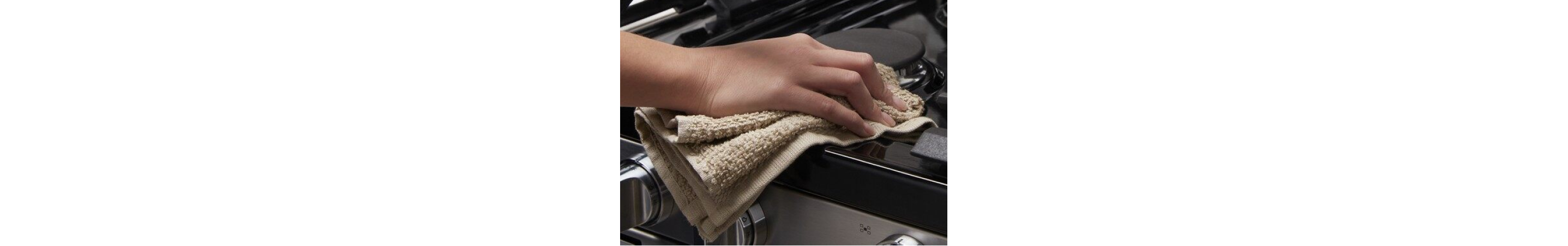 Person wiping around a stovetop burner with a tan cloth