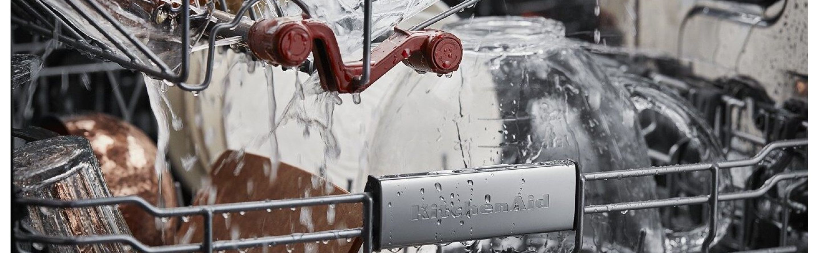 Closeup of the inside of KitchenAid® dishwasher with water spraying on the dishes