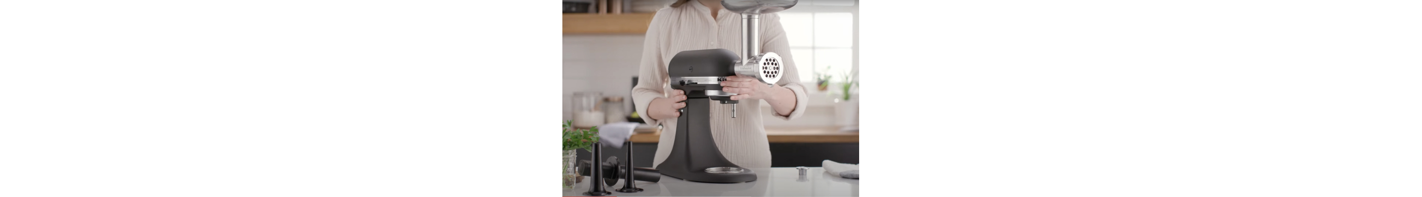 Person attaching the KitchenAid Metal Food Grinder attachment to the stand mixer