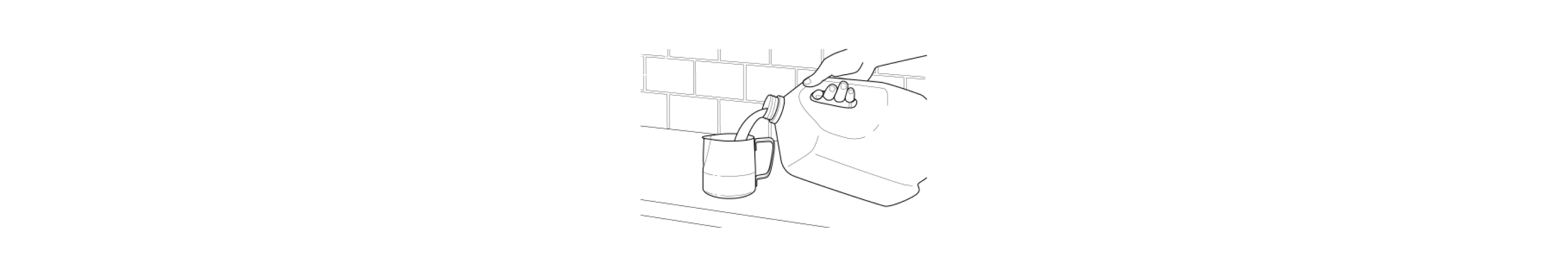  Hand pouring milk from a jug into frothing pitcher