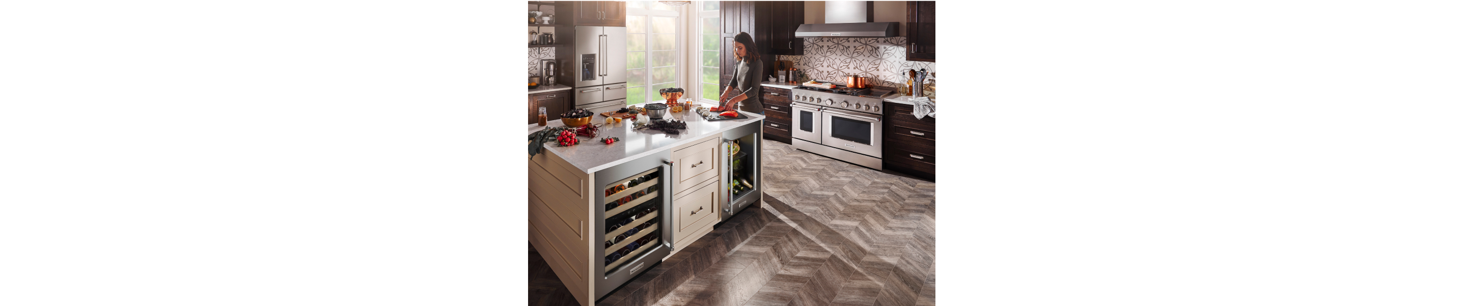 Woman cooking in a kitchen with stainless steel KitchenAid® appliances