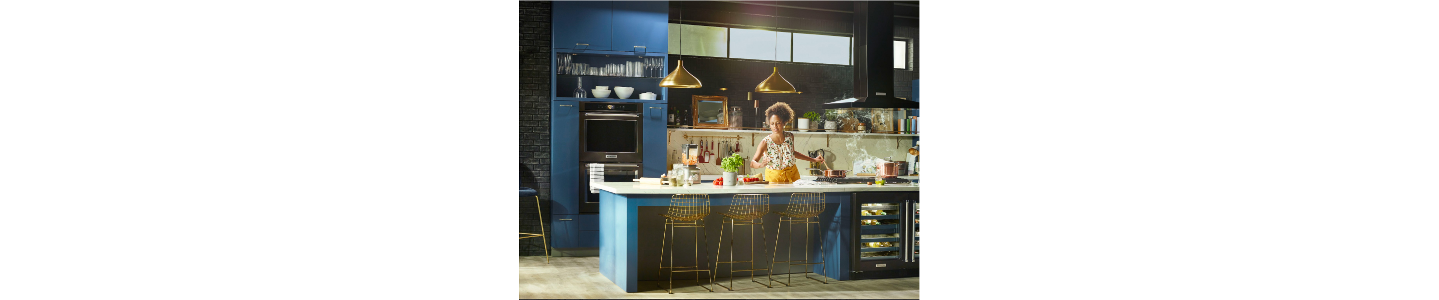 Woman cooking in a kitchen with black stainless steel KitchenAid® appliances
