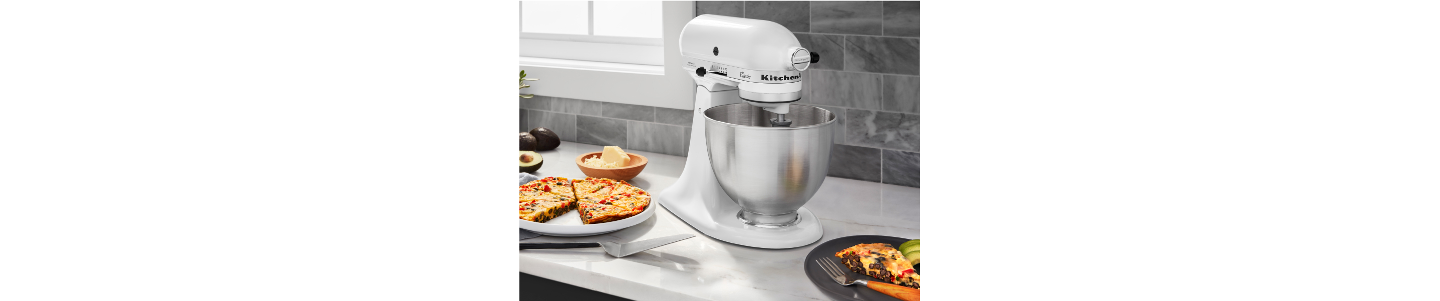 White KitchenAid® stand mixer next to a plate of frittata 
