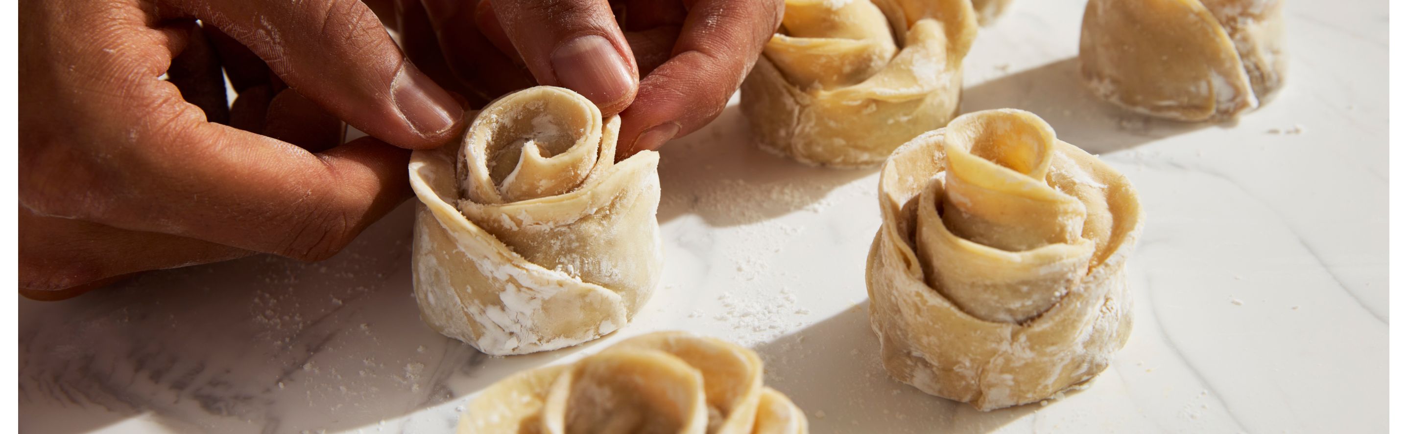 Person creating small flowers with dough
