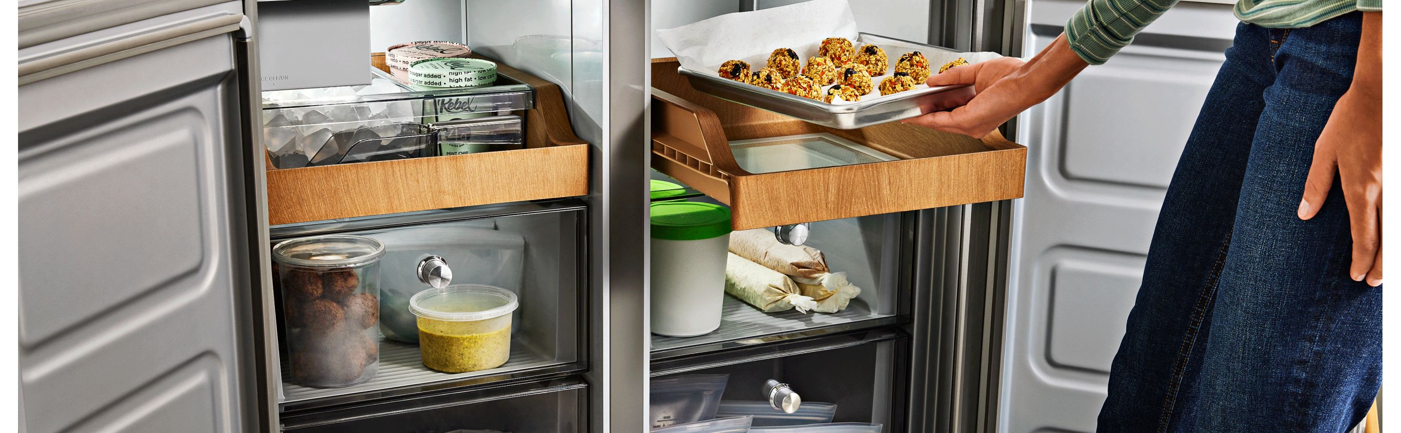 Person placing a tray of cookie dough in the refrigerator