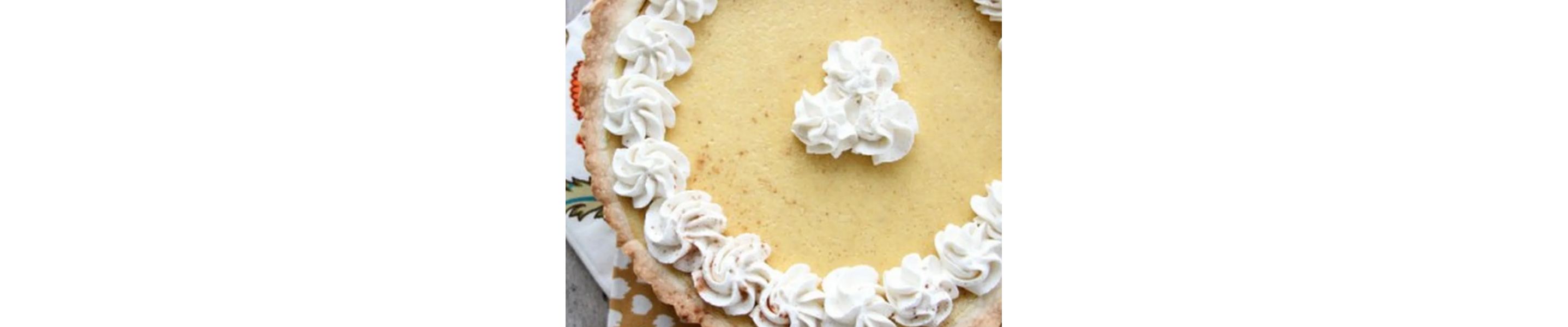 Close-up of pumpkin pie tart with whipped cream garnish