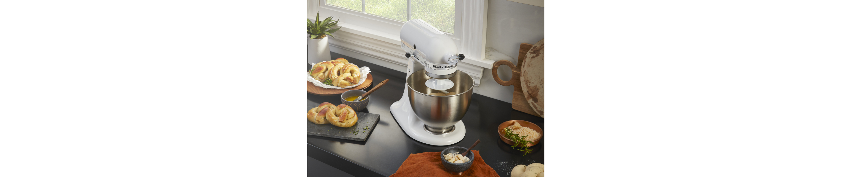 A stand mixer next to freshly baked pretzels 