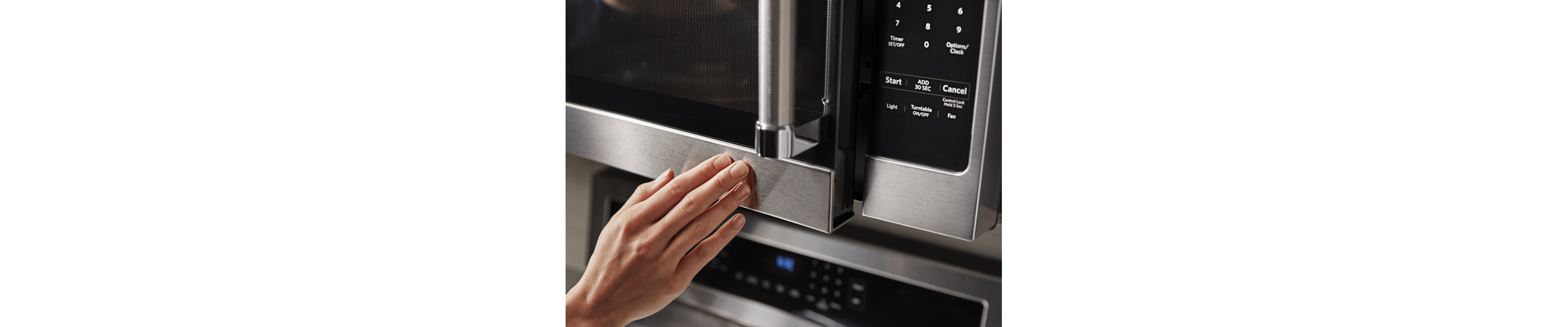 Person closing the door of an over-the-range microwave