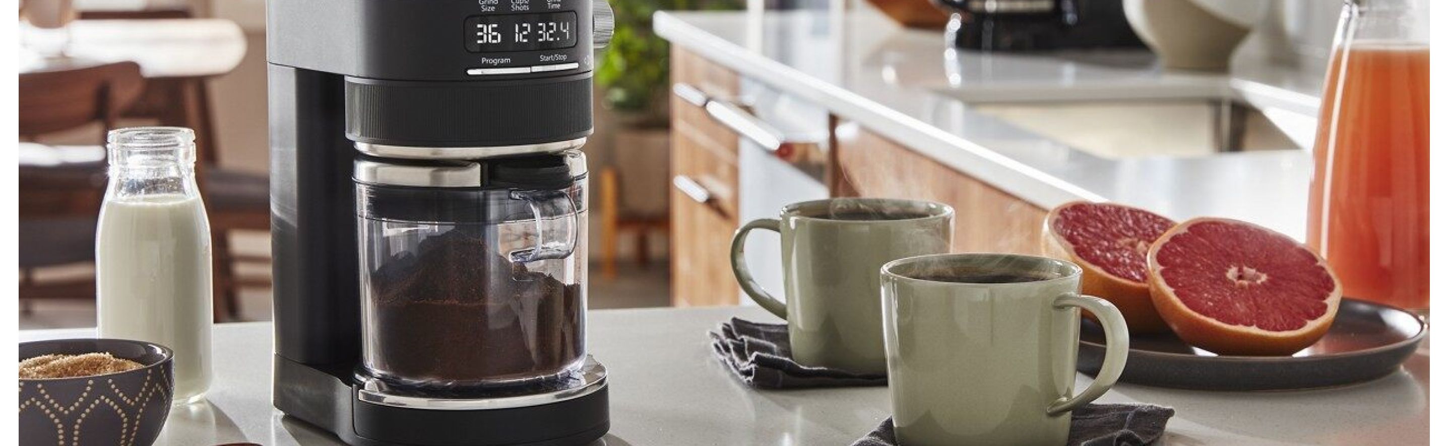 KitchenAid® Burr Coffee Grinder with coffee cups and grapefruit halves.