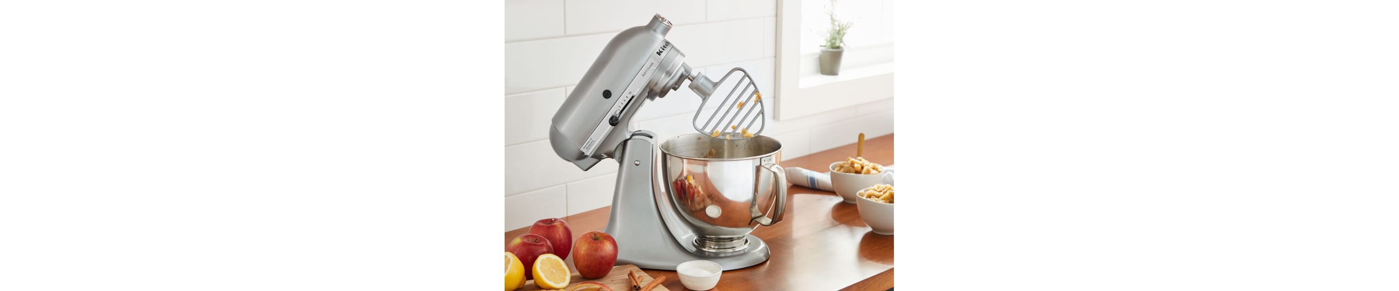 A KitchenAid® stand mixer with a pastry beater accessory on the counter of a modern kitchen.