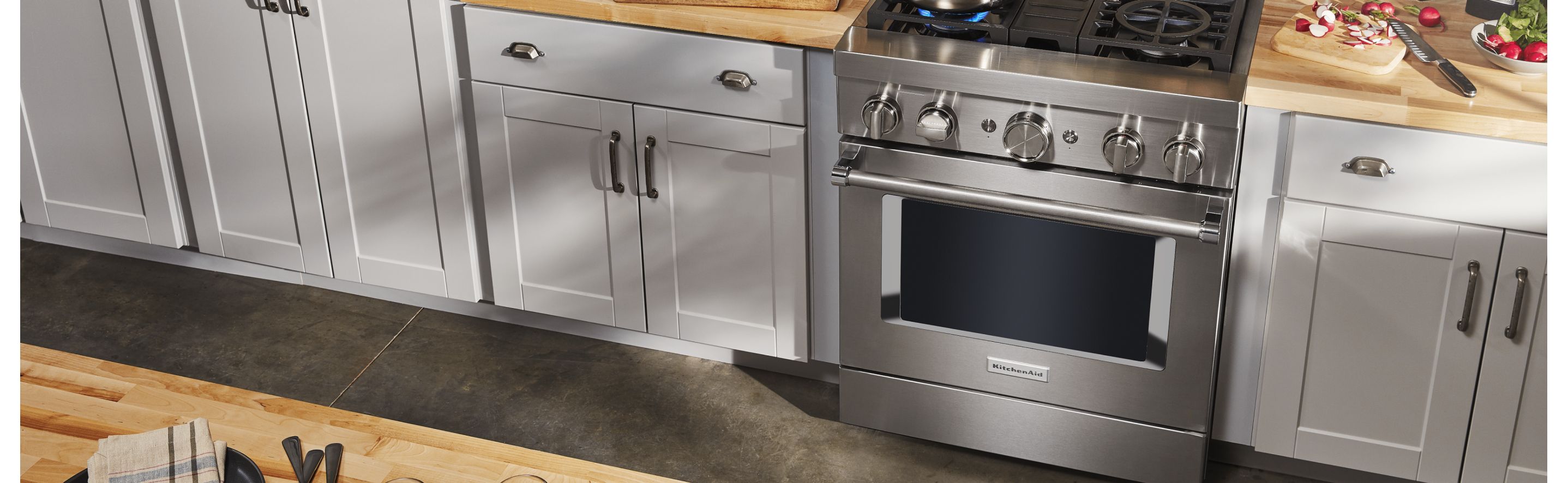Stainless steel commercial-style range in a grey kitchen