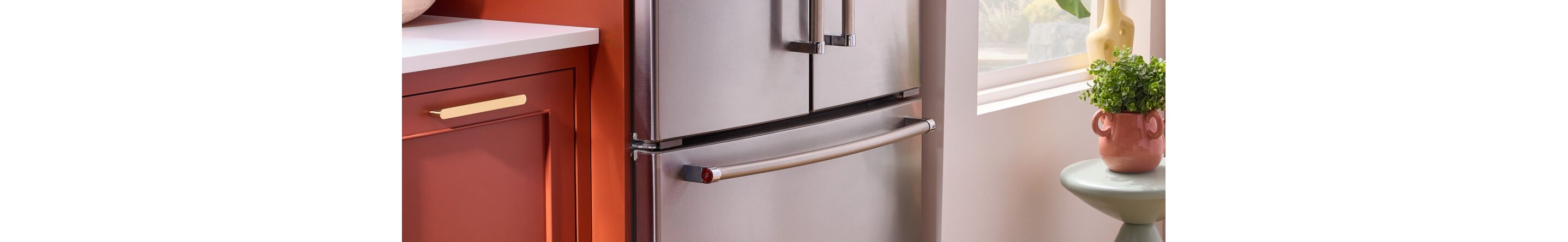 A KitchenAid® French door refrigerator next to terracotta cabinets
